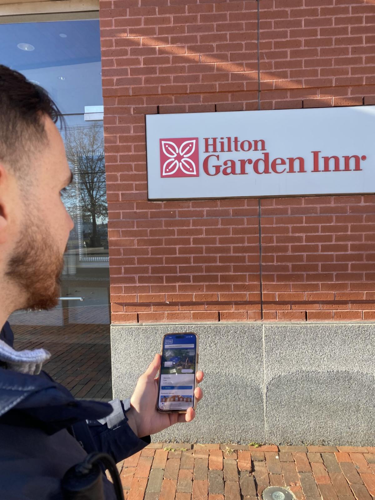 The photo above is of Tyler standing outside of a Hilton Garden Inn using the Hilton Honors app on his phone to navigate the hotel and its amenities